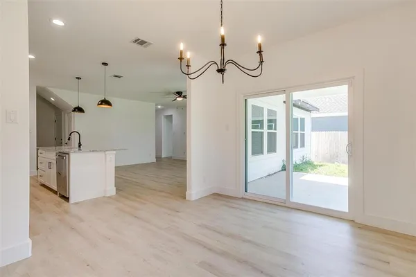 a view of a room with wooden floor fireplace and windows