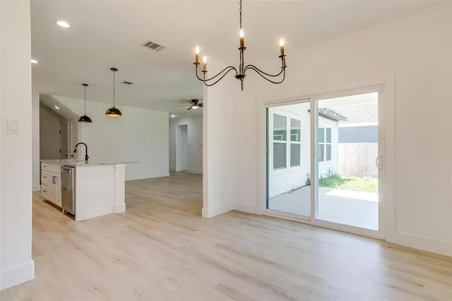 a view of a room with wooden floor fireplace and windows