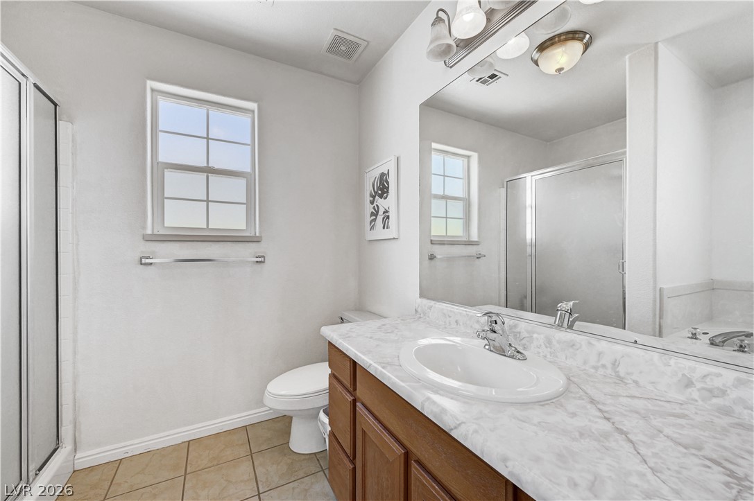 1272 Liston Avenue Logandale, NV 89021 - Photo 39 of 61 A well-lit primary bathroom featuring a spacious vanity and a convenient glass-enclosed shower.
