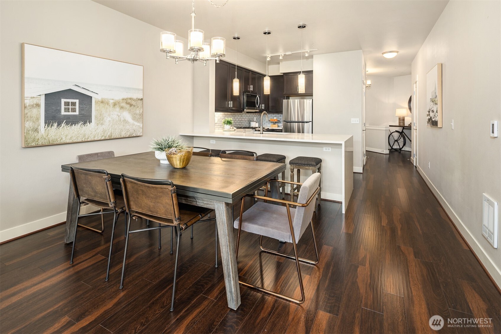 15700 116th Avenue Northeast, Unit 404 Bothell, WA 98011 - Photo 9 of 31 a kitchen with stainless steel appliances kitchen island granite countertop a dining table chairs and a refrigerator