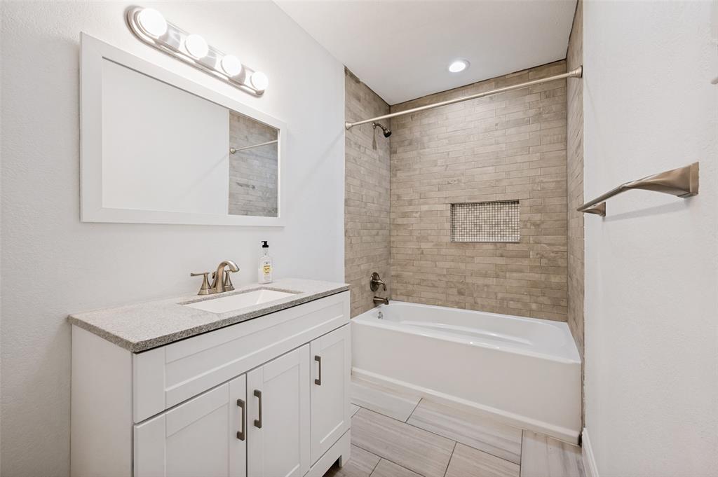 2316 Cunningham Street Irving, TX 75062 - Photo 13 of 22 Primary bathroom featuring a white vanity with a light-colored countertop, an integrated sink, and brushed nickel hardware