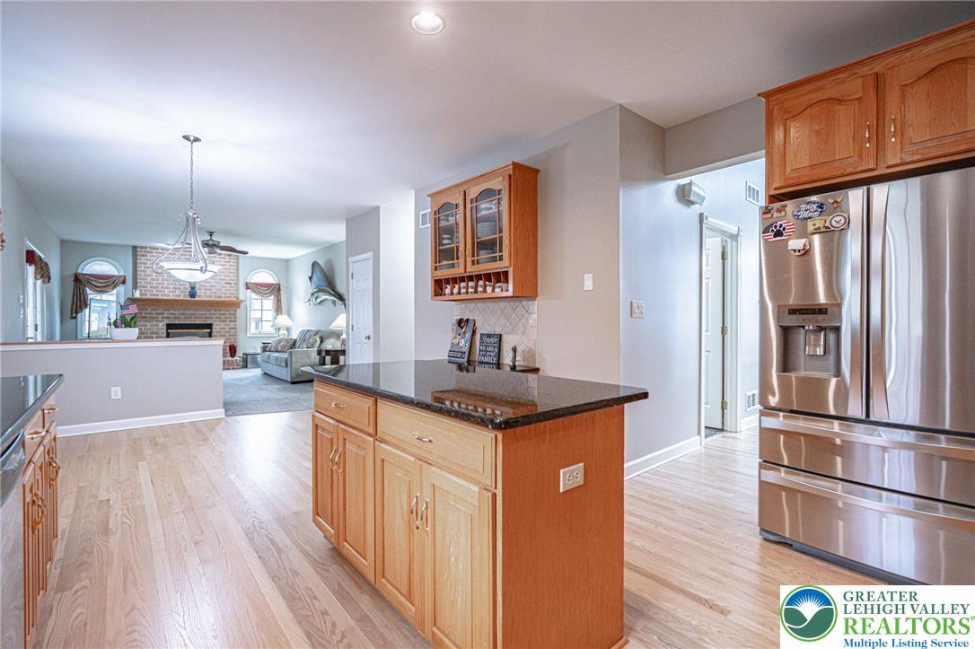 6551 Overlook Road Orefield, PA 18069 - Photo 26 of 82 a kitchen with stainless steel appliances granite countertop a refrigerator a sink dishwasher a stove and a dining table with wooden floor
