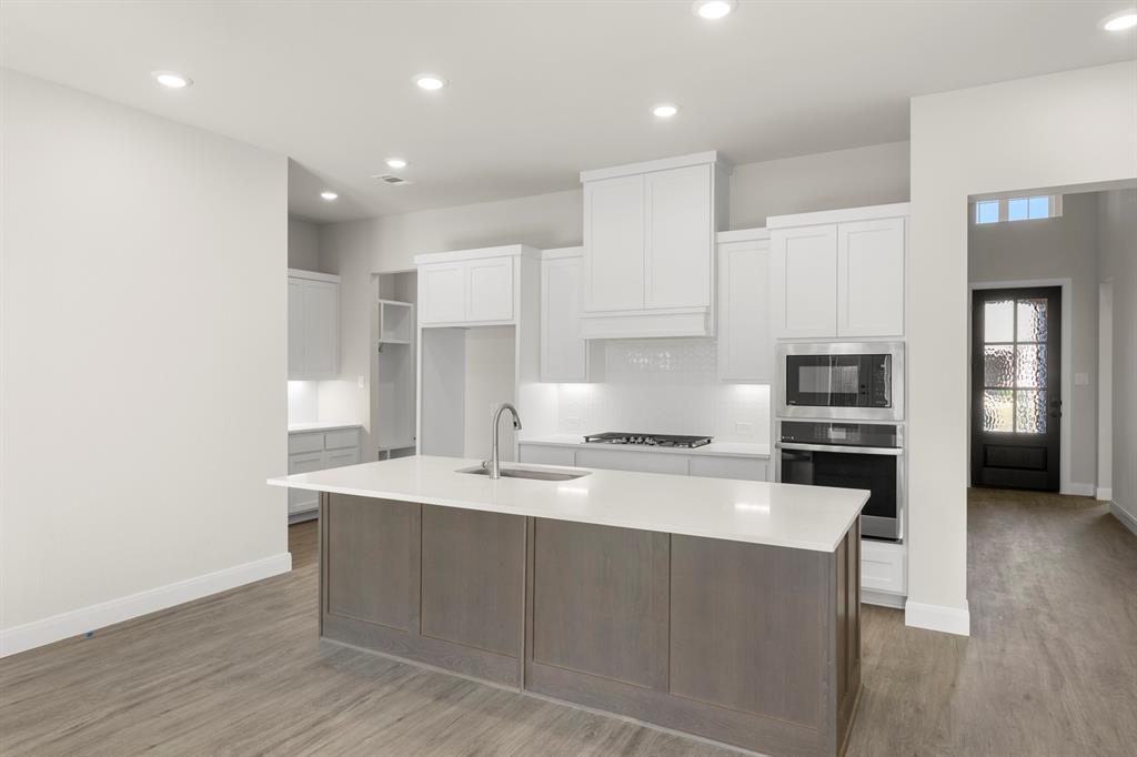 1201 Century Tree Lane Anna, TX 75409 - Photo 8 of 26 a large kitchen with stainless steel appliances kitchen island granite countertop a stove a sink and a refrigerator