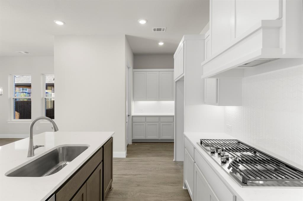 1201 Century Tree Lane Anna, TX 75409 - Photo 9 of 26 a kitchen with a sink a stove and cabinets