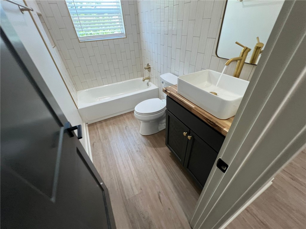 4501 College Main Street, Unit 1 Bryan, TX 77801 - Photo 6 of 8 a bathroom with a sink a toilet a tub and shower