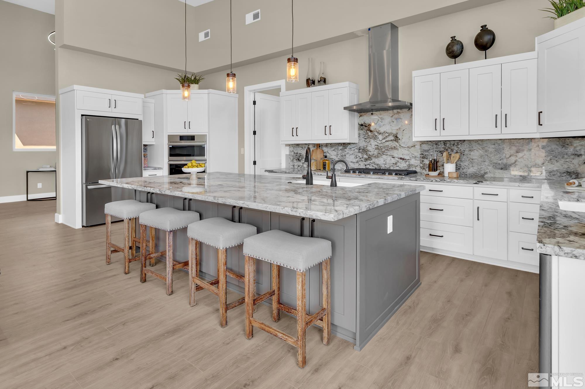 724 Canter Way Reno, NV 89511 - Photo 13 of 40 a large kitchen with stainless steel appliances granite countertop a table chairs sink and cabinets