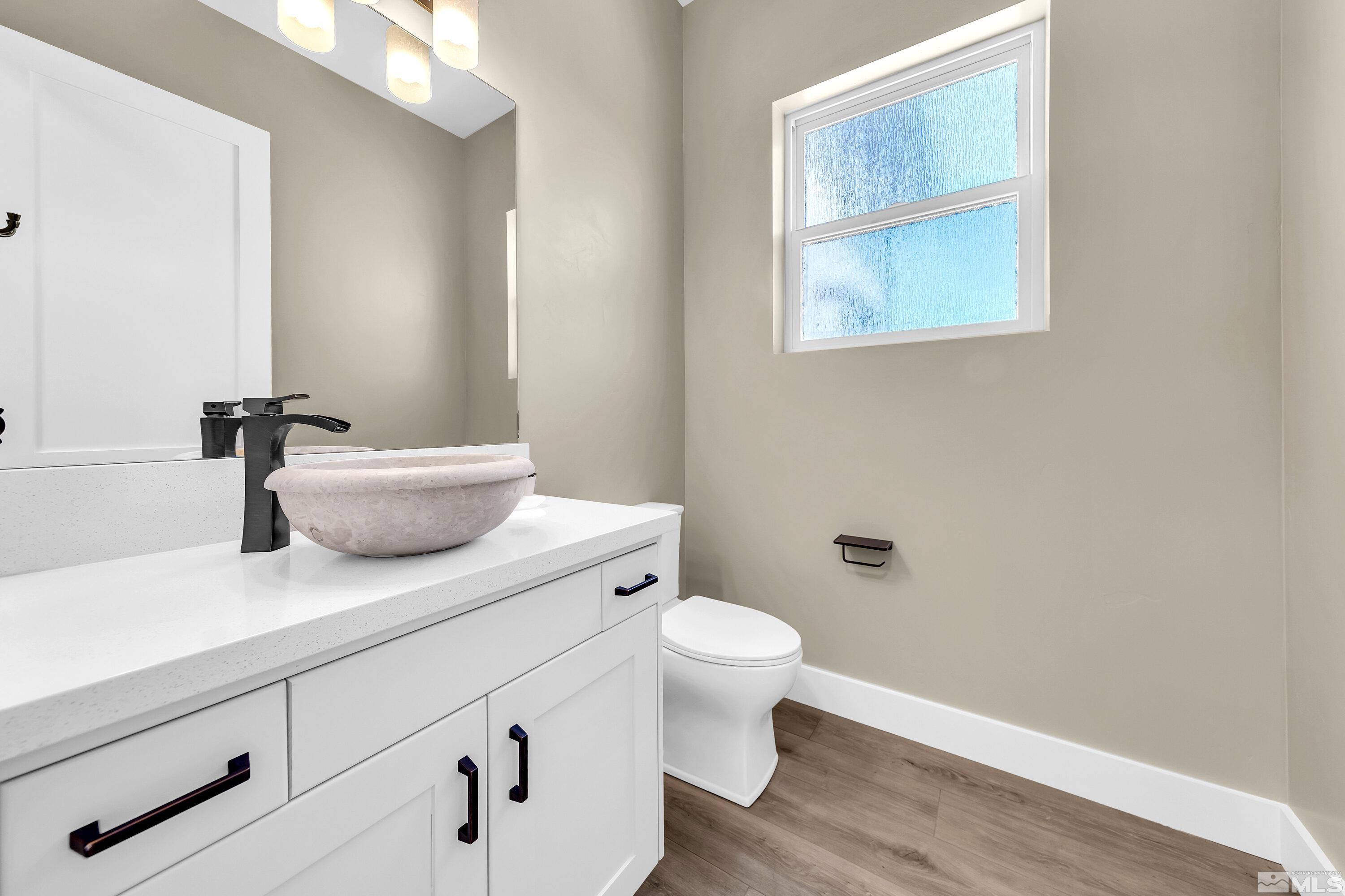 724 Canter Way Reno, NV 89511 - Photo 19 of 40 a bathroom with a granite countertop sink a toilet and a mirror