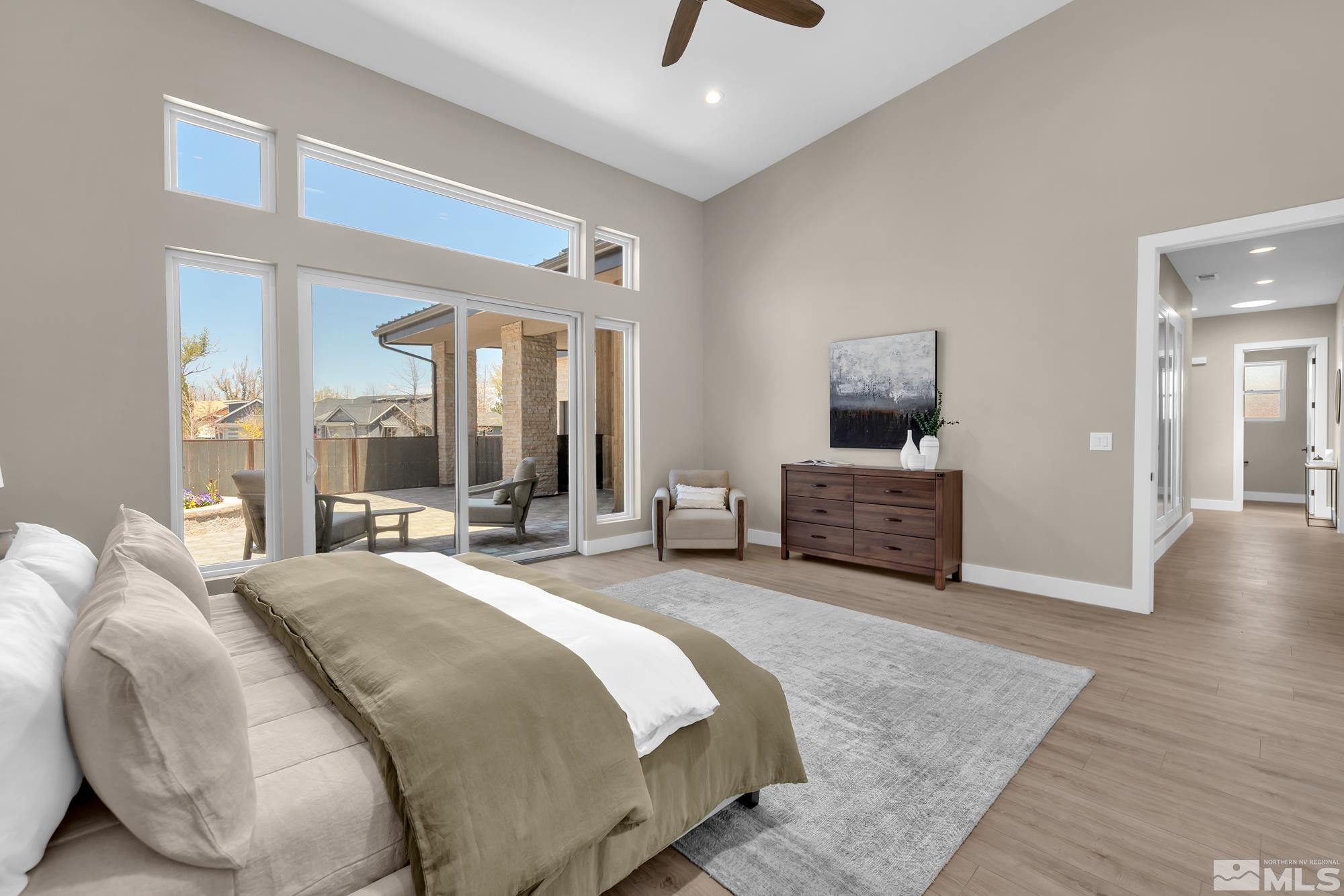 724 Canter Way Reno, NV 89511 - Photo 24 of 40 a spacious bedroom with a bed a mirror on dresser and a wooden floor