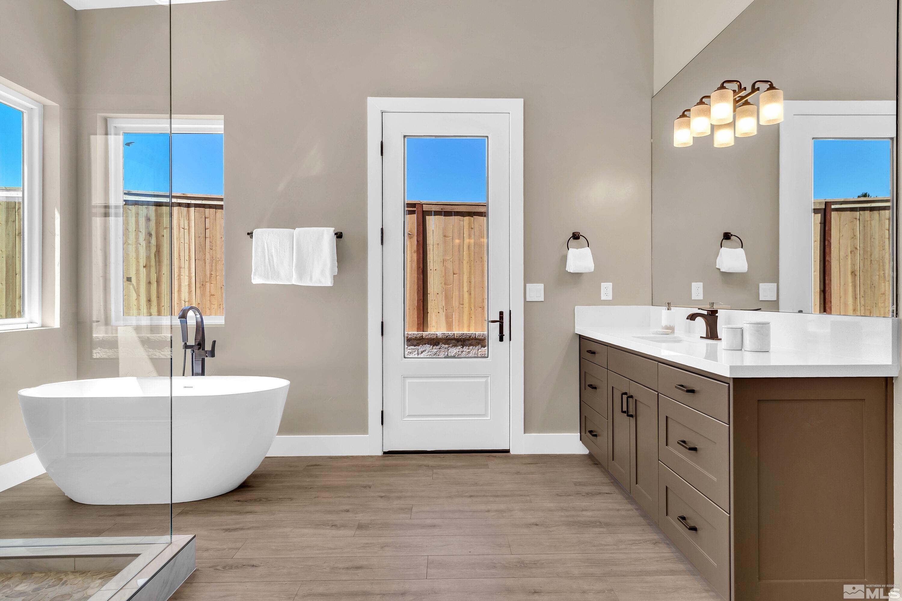 724 Canter Way Reno, NV 89511 - Photo 27 of 40 a spacious bathroom with a double vanity sink a mirror and a bathtub