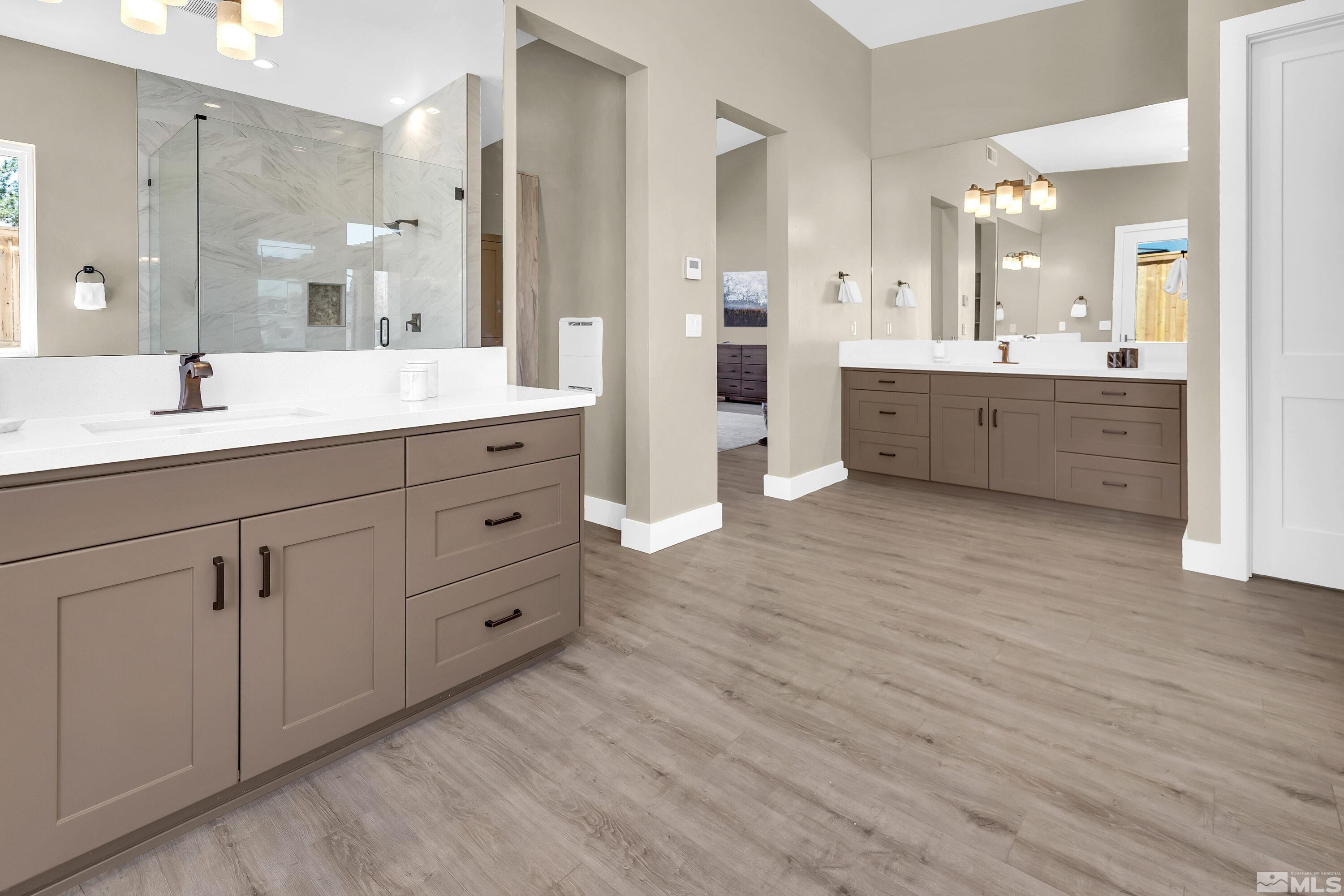 724 Canter Way Reno, NV 89511 - Photo 28 of 40 a bathroom with a double vanity sink a mirror and a bathtub