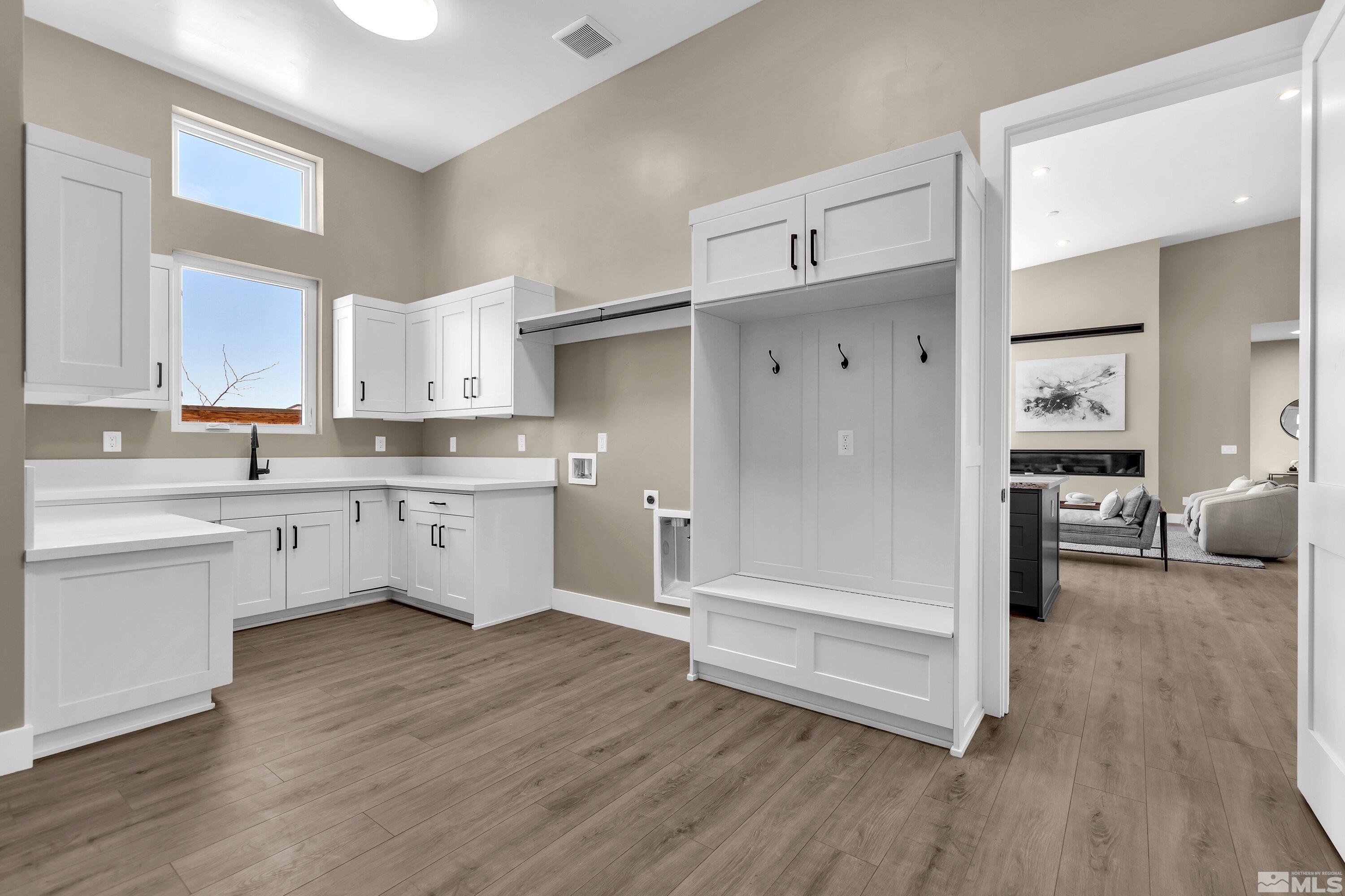 724 Canter Way Reno, NV 89511 - Photo 30 of 40 a kitchen with wooden floors and white cabinets