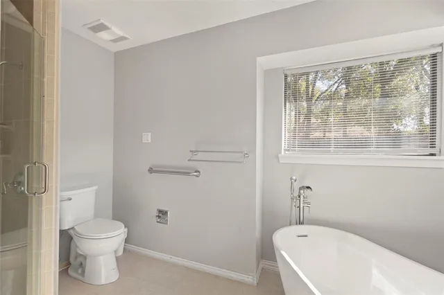 a bathroom with a toilet and a shower