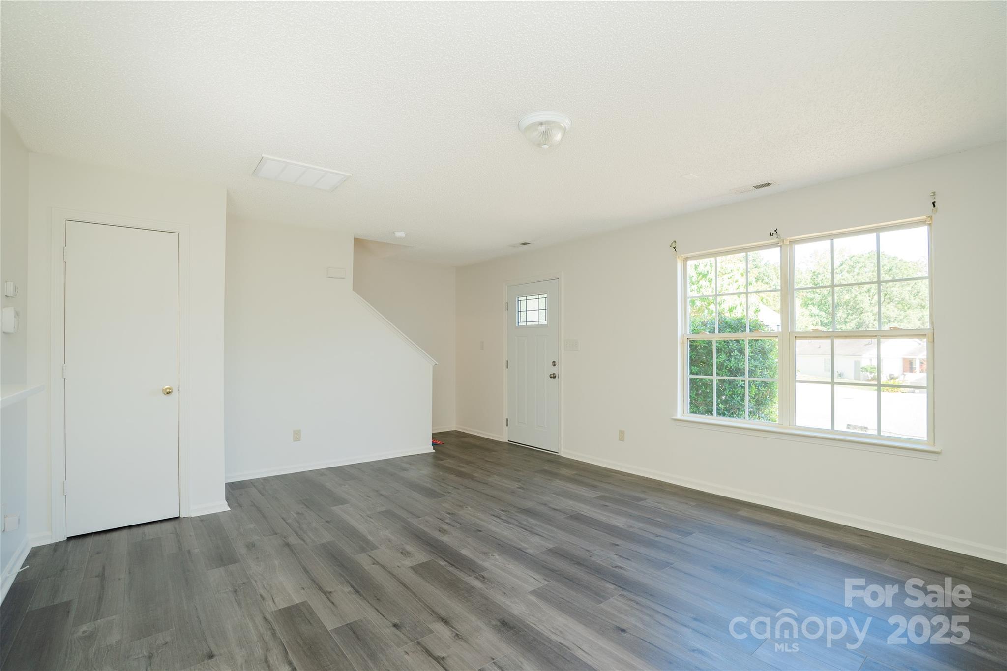 2893 Signal Court Southwest Concord, NC 28025 - Photo 5 of 32 an empty room with wooden floor and windows