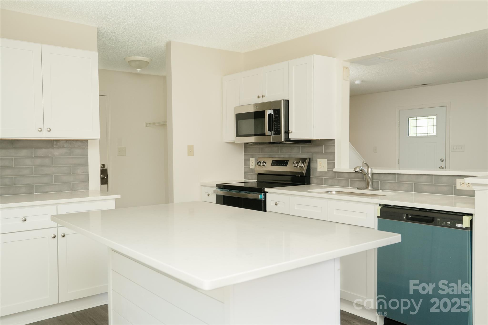 2893 Signal Court Southwest Concord, NC 28025 - Photo 8 of 32 a kitchen with a sink a stove and cabinets