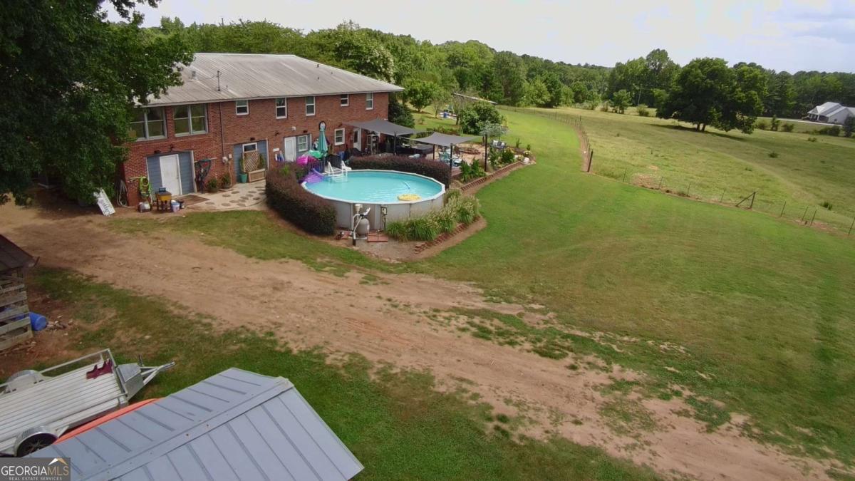 876 Simpson Mill Road Locust Grove, GA 30248 - Photo 16 of 51 a view of a patio with lawn chairs under an umbrella