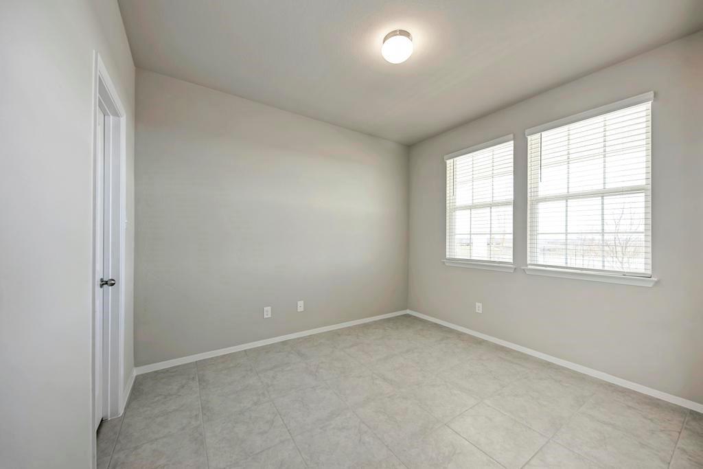 1209 Goforth Road Kyle, TX 78640 - Photo 20 of 32 Two large windows provide ample natural light, complementing the cool-toned tile flooring in this inviting room.