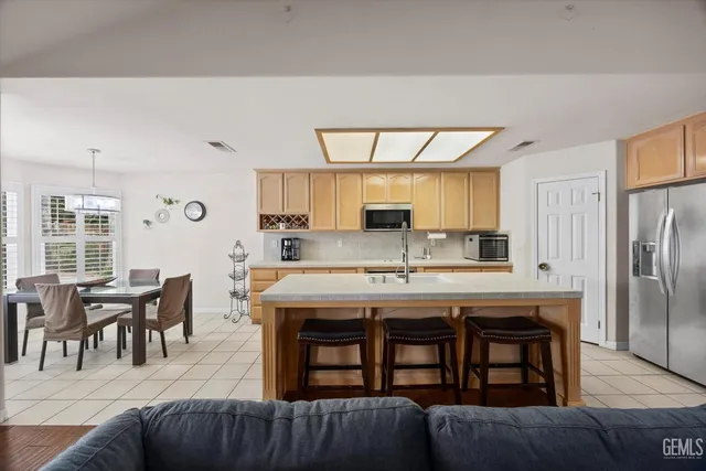 a kitchen with a table chairs refrigerator and cabinets