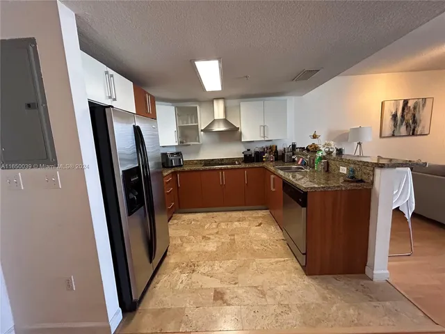 a kitchen with stainless steel appliances granite countertop a refrigerator stove and sink