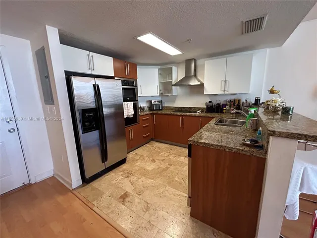 a kitchen with stainless steel appliances granite countertop a refrigerator stove and sink