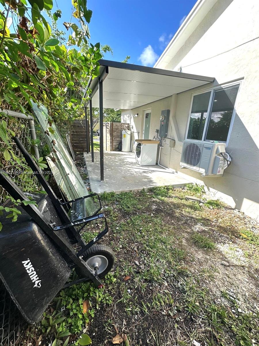 26205 Southwest 133rd Court, Unit 2 Homestead, FL 33032 - Photo 15 of 17 a view of a backyard with floor to ceiling window and potted plants