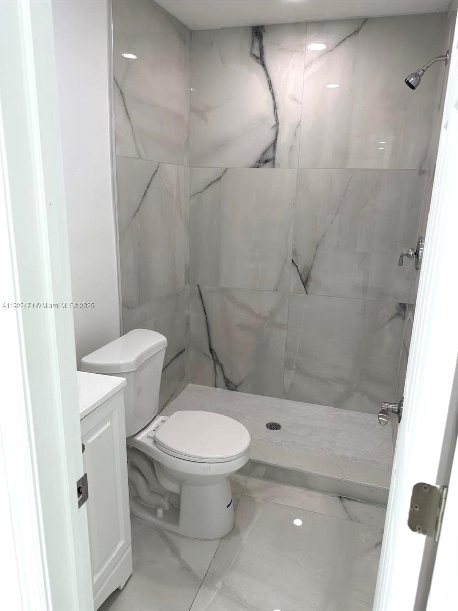 26205 Southwest 133rd Court, Unit 2 Homestead, FL 33032 - Photo 5 of 17 a white toilet sitting next to a bath tub