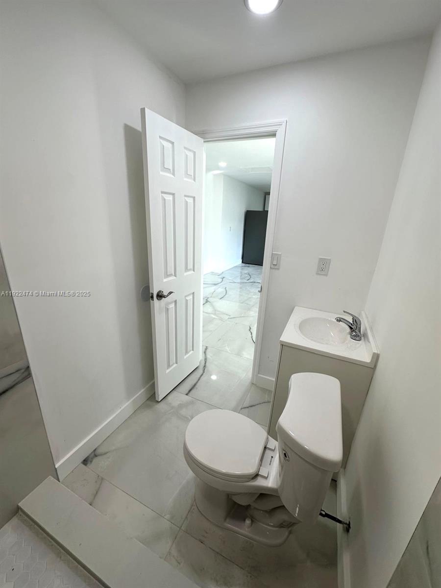 26205 Southwest 133rd Court, Unit 2 Homestead, FL 33032 - Photo 9 of 17 a white toilet sitting next to a bathroom sink