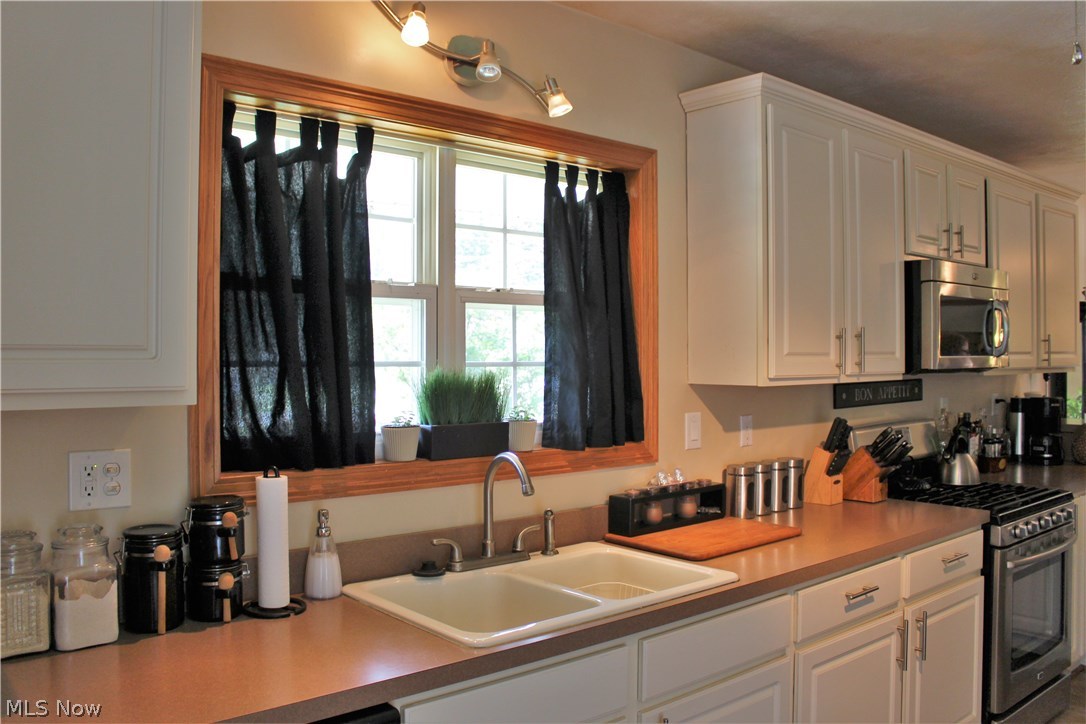 10471 Prouty Road Painesville, OH 44077 - Photo 4 of 33 Kitchen with lots of cabinet space. Newer 5 burner range and microwave.