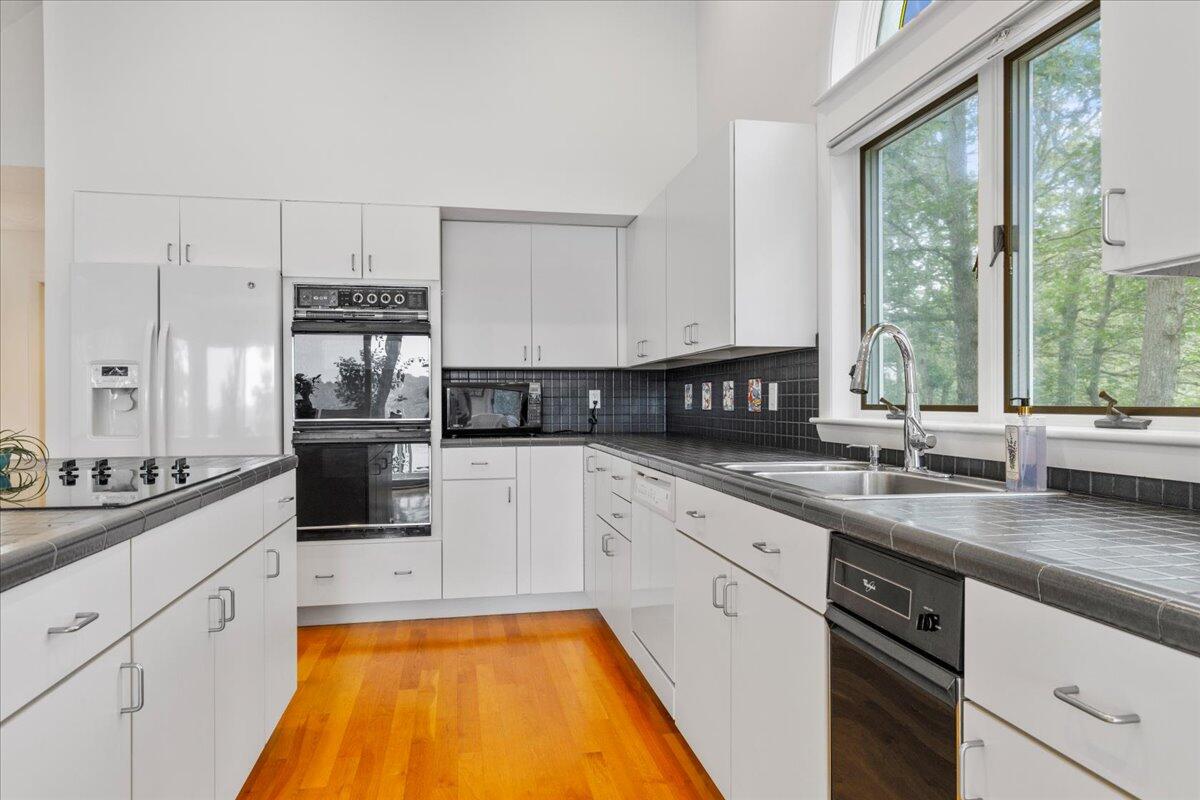 19 Ockway Bay Road Mashpee, MA 02649 - Photo 18 of 79 a kitchen with stainless steel appliances a sink a stove and white cabinets next to a window