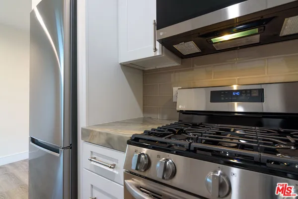 a stove top oven sitting inside of a kitchen