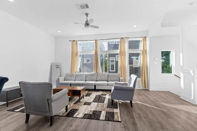 a living room with furniture and large windows