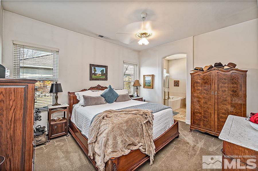 10155 Buckeye Court Reno, NV 89521 - Photo 11 of 17 a spacious bedroom with a bed and a chandelier