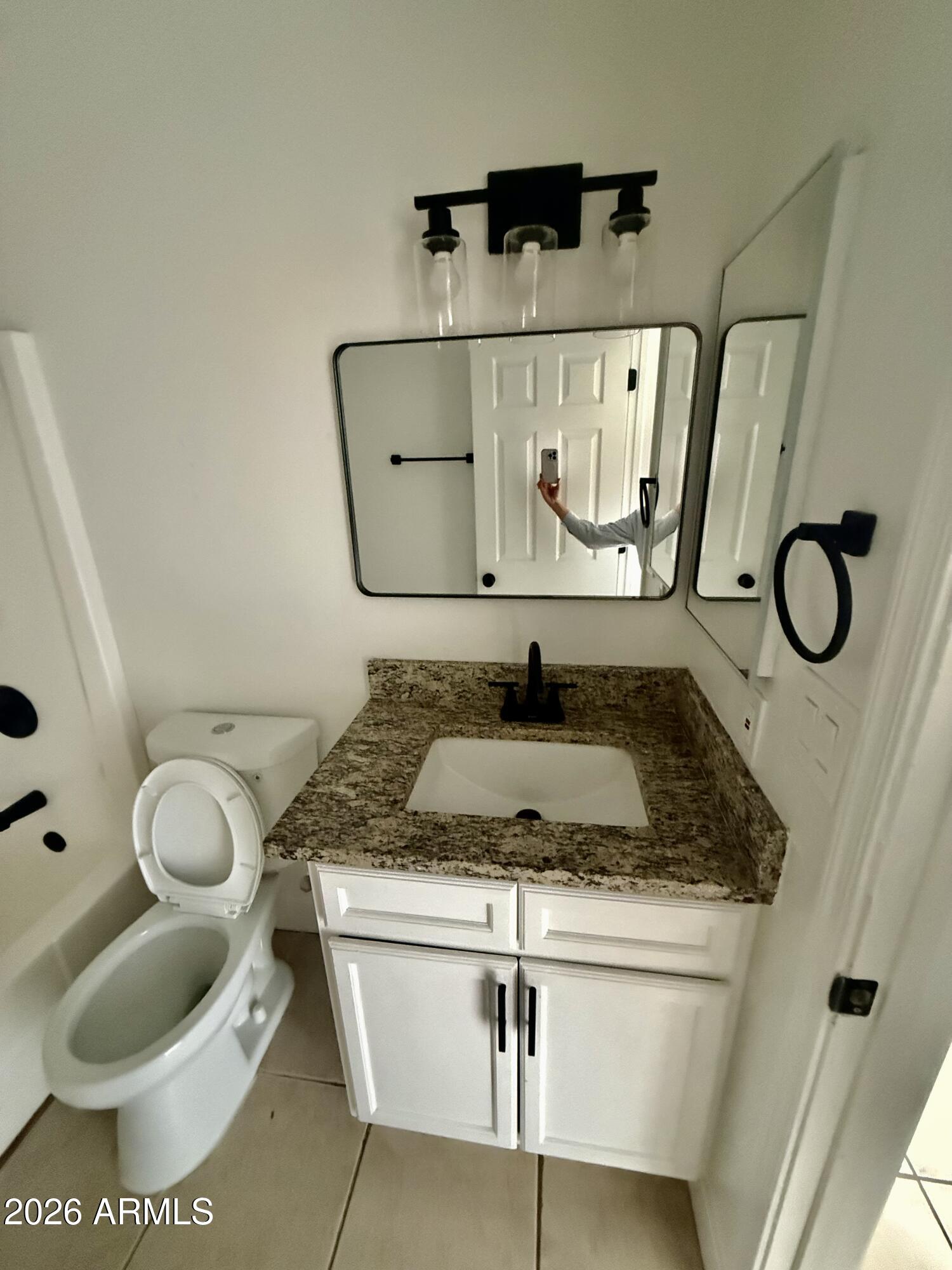 6963 West Rancho Drive Glendale, AZ 85303 - Photo 5 of 14 a bathroom with a granite countertop toilet sink and mirror