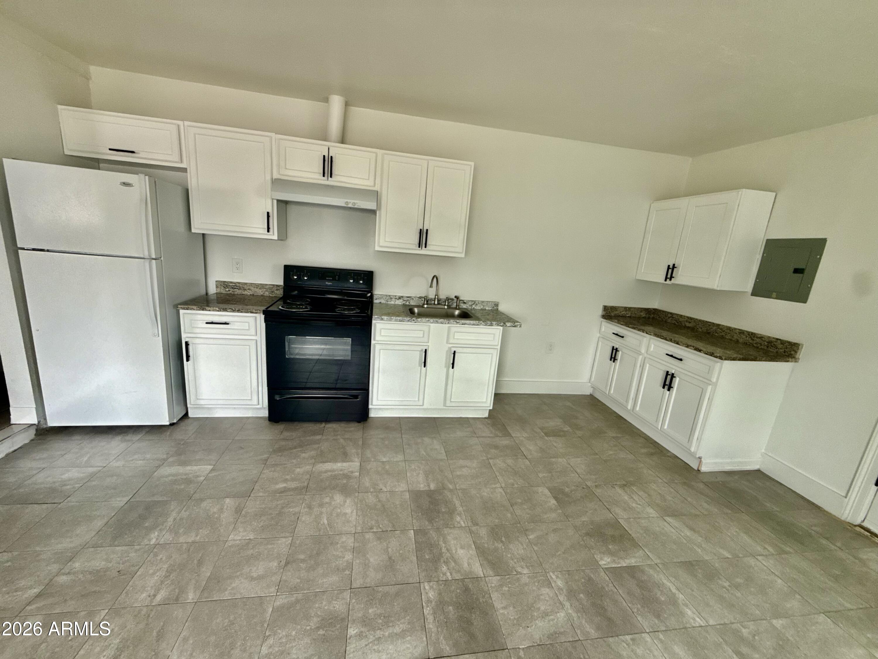 6963 West Rancho Drive Glendale, AZ 85303 - Photo 8 of 14 a kitchen with stainless steel appliances granite countertop a stove a refrigerator and a granite counter tops