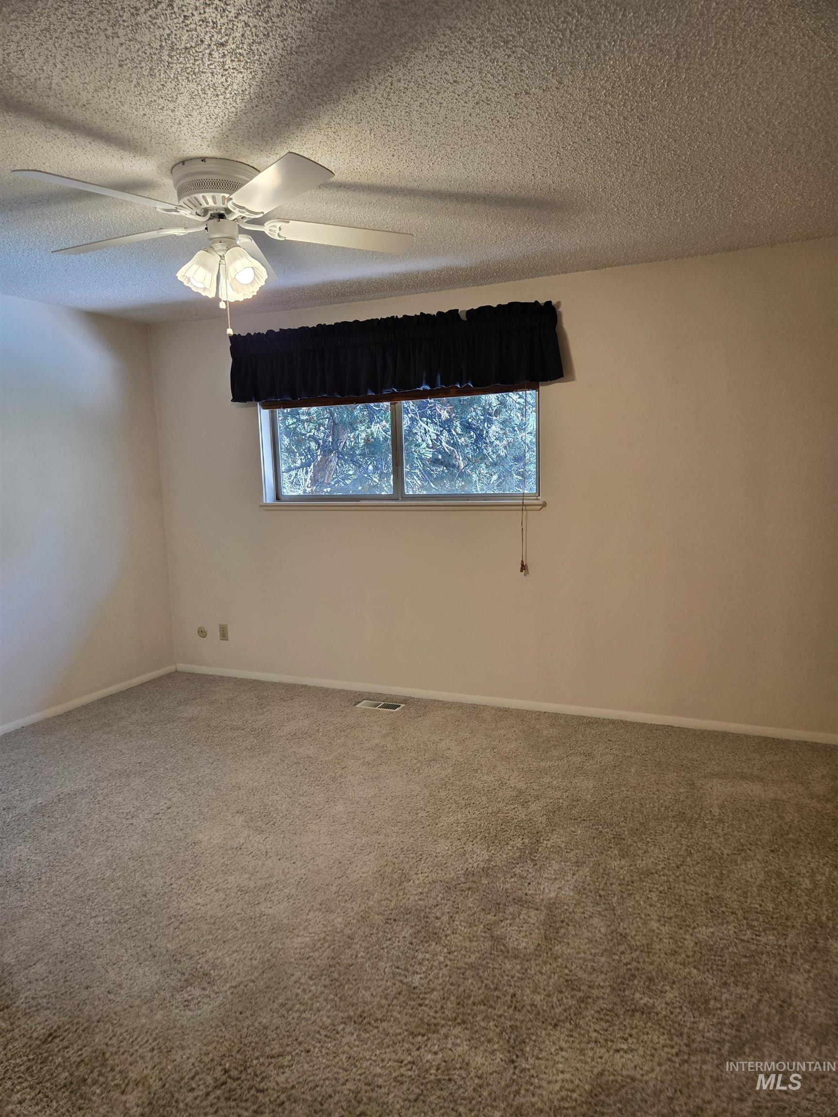 12050 West Hidden Valley Rim Road Boise, ID 83709 - Photo 12 of 39 Carpeted room featuring a ceiling fan with integrated lighting, a window with a valance, and neutral wall tones
