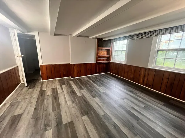 a view of empty room with wooden floor