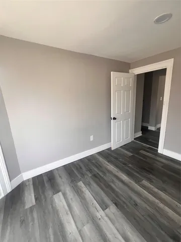an empty room with wooden floor and closet