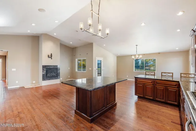a kitchen with stainless steel appliances granite countertop wooden floors and granite counter tops