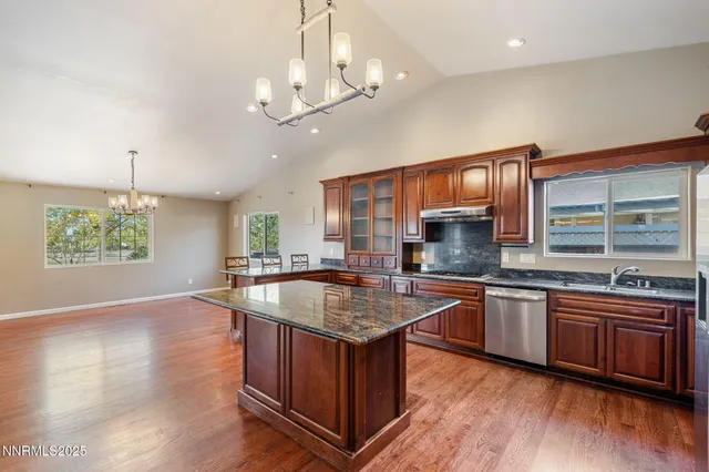 a kitchen with stainless steel appliances granite countertop a sink stove and wooden floor