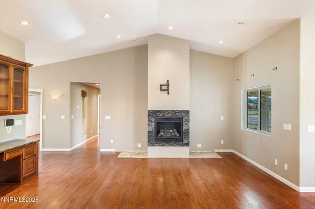 a view of a livingroom with wooden floor and a fireplace