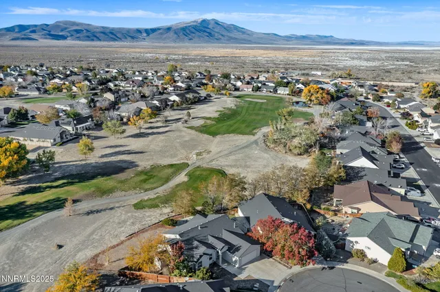 an aerial view of a city with lots of residential buildings and mountain view in back
