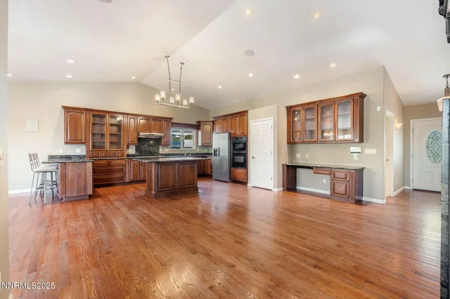a open kitchen with stainless steel appliances granite countertop a stove and a refrigerator