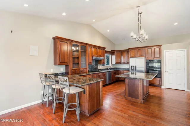 a kitchen with stainless steel appliances wooden floor and dining table