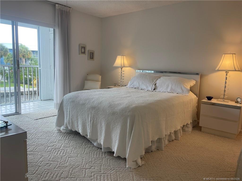 1858 Southwest Palm City Road, Unit 203 Stuart, FL 34994 - Photo 13 of 21 a bedroom with a bed and a lamp