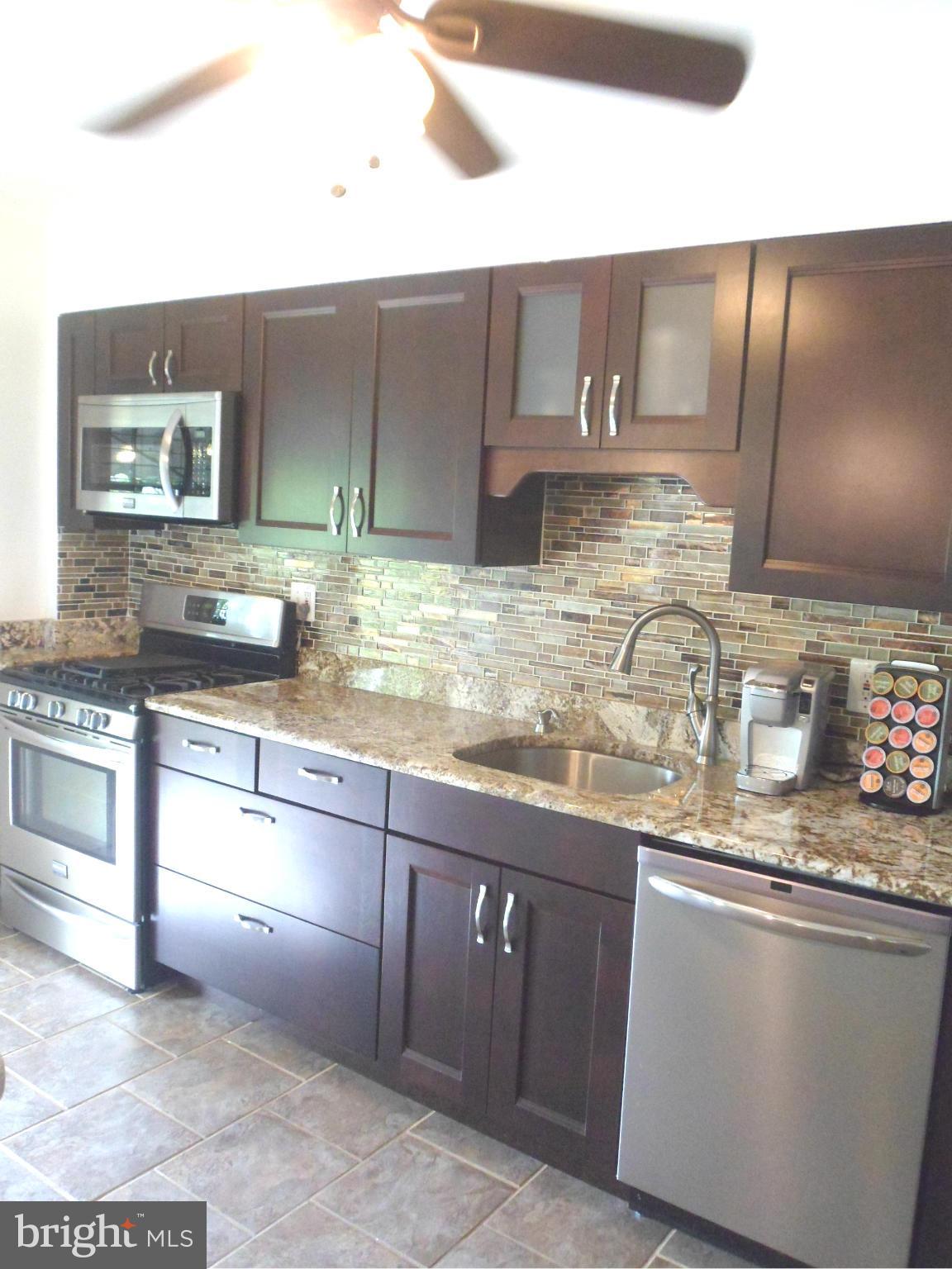 6110 Marlora Road Baltimore, MD 21239 - Photo 7 of 22 a kitchen with granite countertop a sink a stove and cabinets
