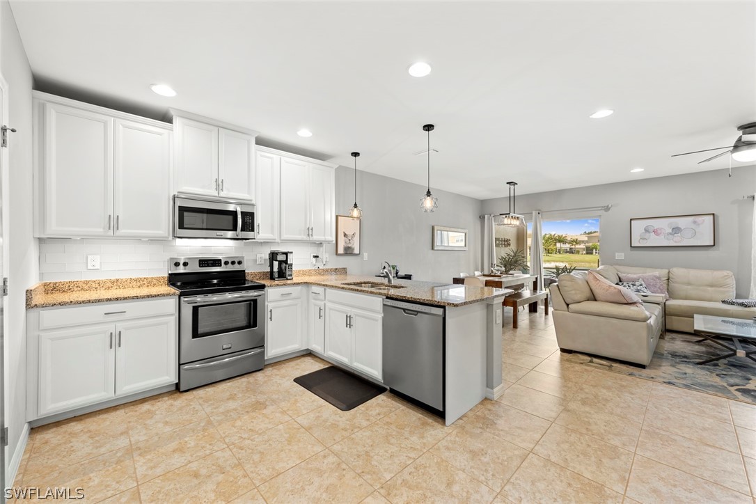 3849 Tilbor Circle Fort Myers, FL 33916 - Photo 4 of 28 a kitchen with stainless steel appliances kitchen island granite countertop a sink and white cabinets