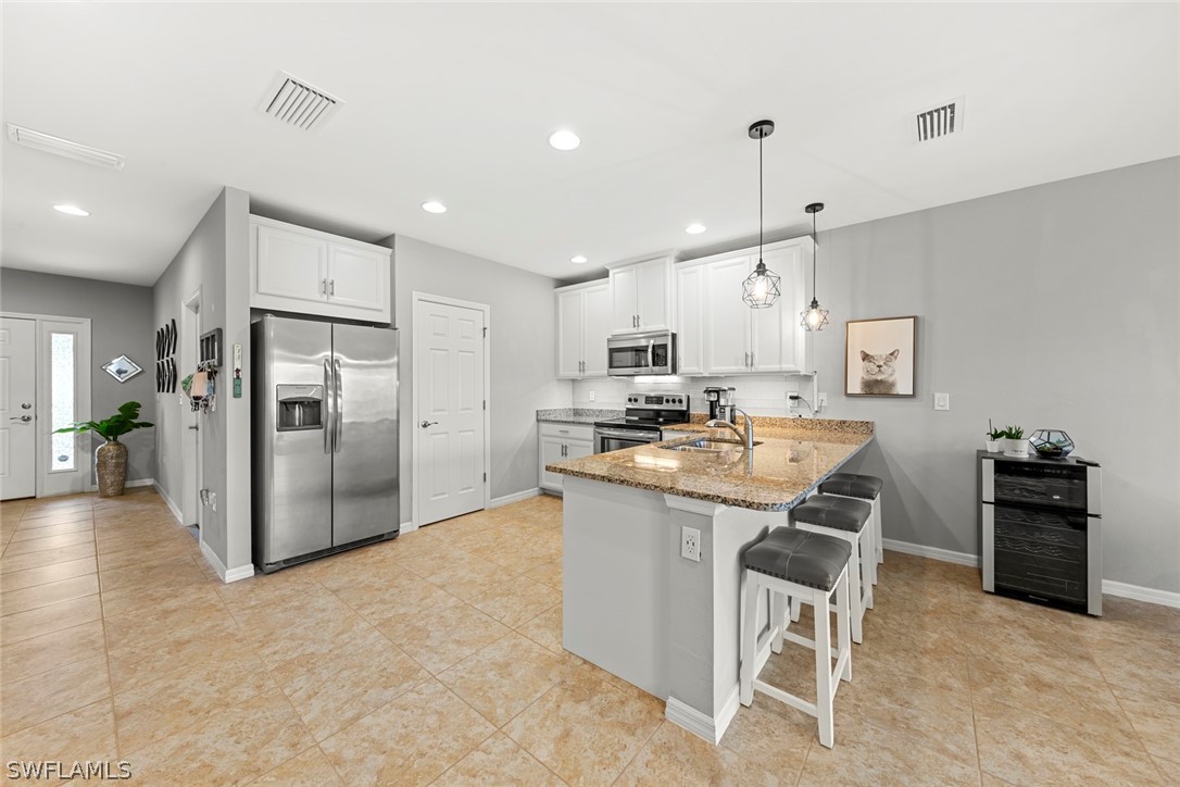 3849 Tilbor Circle Fort Myers, FL 33916 - Photo 5 of 28 a kitchen with kitchen island a refrigerator and a stove