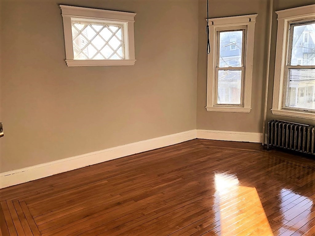 19 Arden Street, Unit 2 Boston, MA 02134 - Photo 2 of 8 a view of an empty room with wooden floor and a window