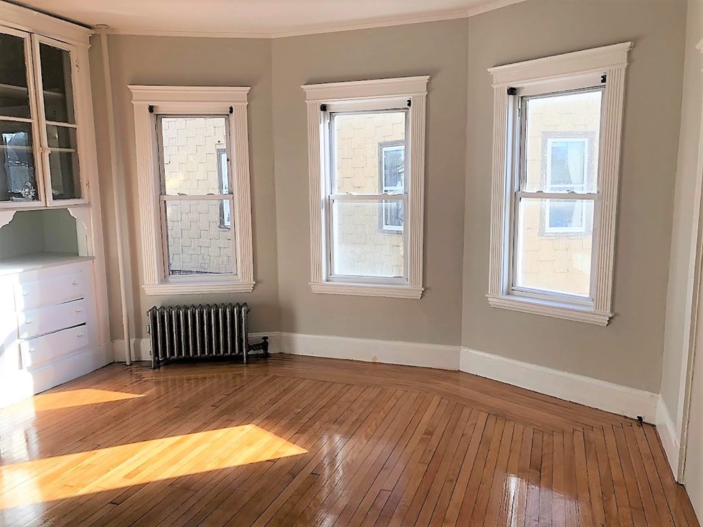 19 Arden Street, Unit 2 Boston, MA 02134 - Photo 4 of 8 an empty room with wooden floor and windows