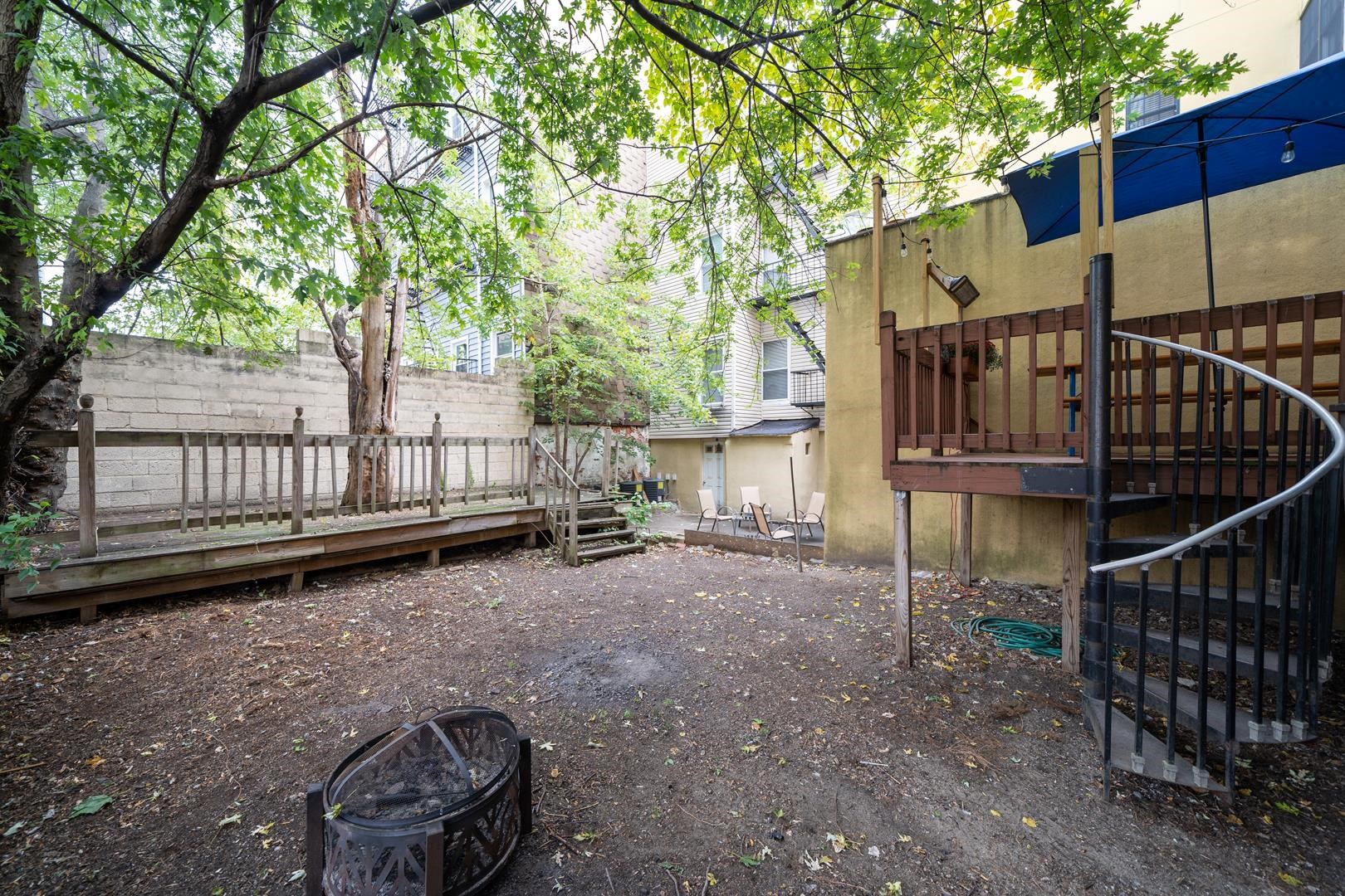 554 Observer Highway, Unit 1R Hoboken, NJ 07030 - Photo 19 of 21 a backyard of a house with a small deck and wooden fence