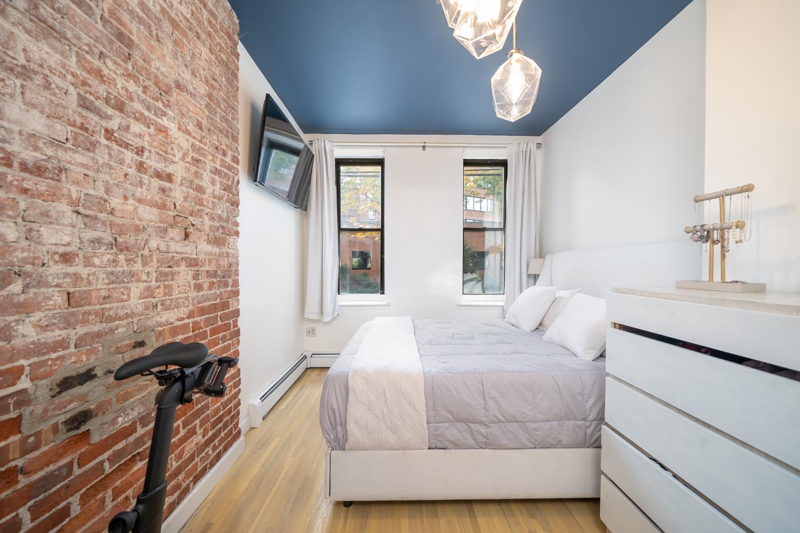 554 Observer Highway, Unit 1R Hoboken, NJ 07030 - Photo 9 of 21 a bedroom with a bed and a flat tv screen on dresser